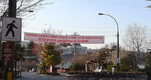 Self-isolation produces empty streets in Langford, lots of physical distancing COVID-Langford banner, Help Line, Goldstream Avenue, April 2020